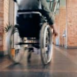 Rollstuhlfahrer fährt einen Korridor entlang