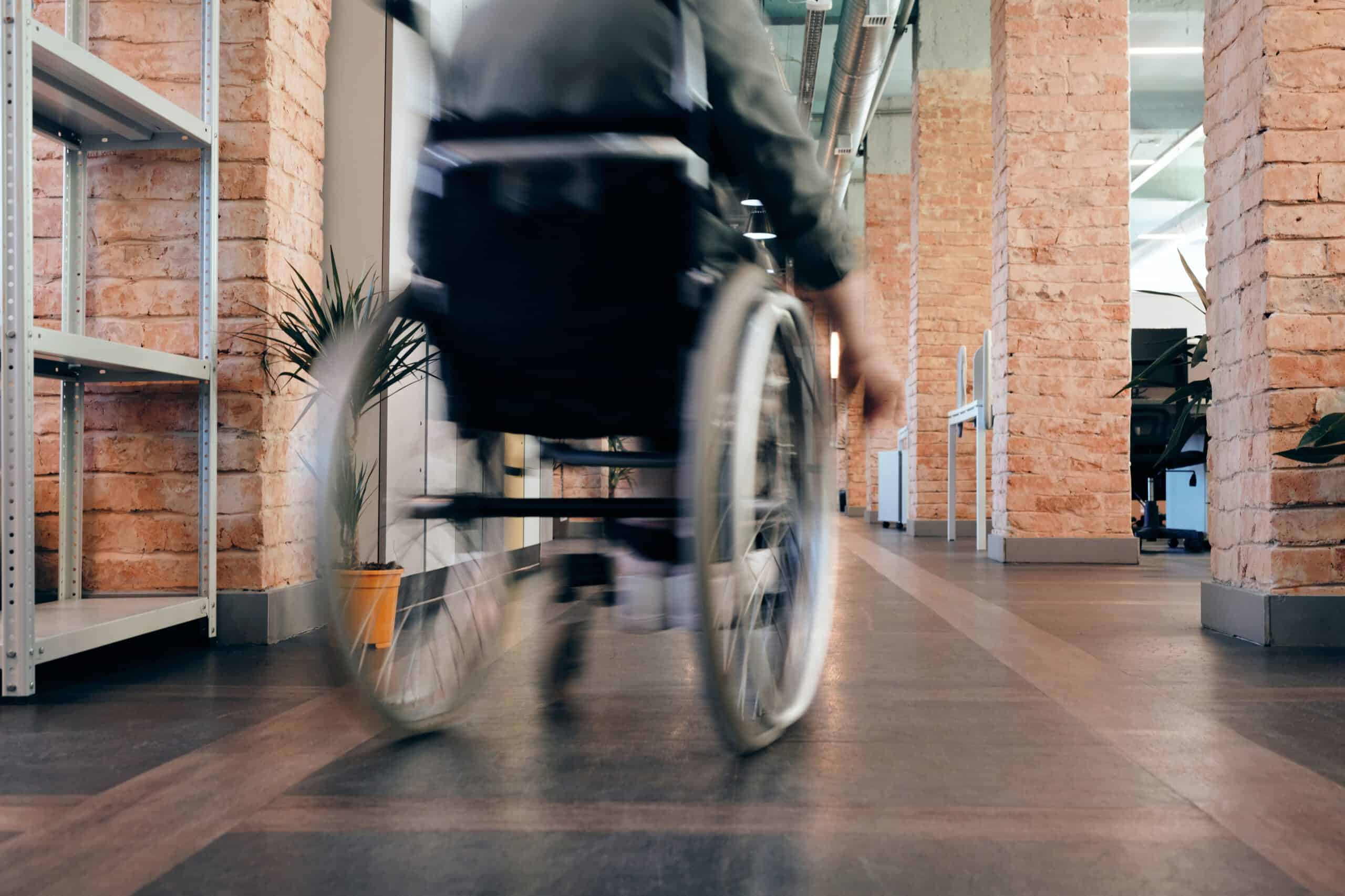 Rollstuhlfahrer fährt einen Korridor entlang